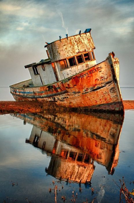 سفينة قديمة مدمرةعلي جزيرة صغيرة وسط البحر - صورة سفينة قديمة مدمرةعلي جزيرة صغيرة وسط البحر