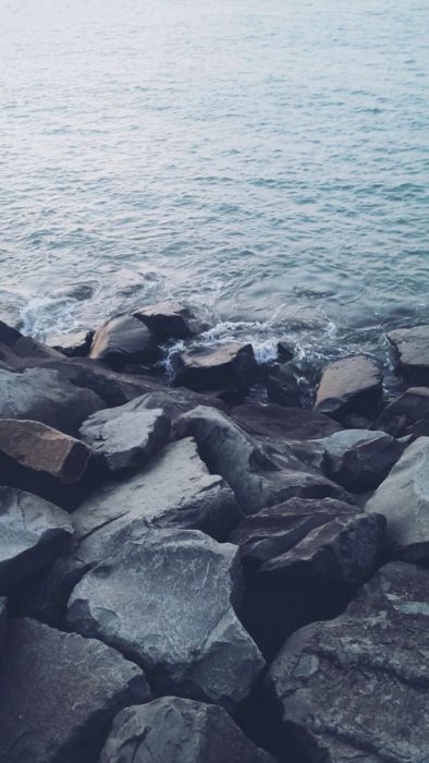 صورة شاطئ صخري وأمواج ترتطم بالصخور السوداء القاسية - صورة شاطئ صخري وأمواج ترتطم بالصخور السوداء القاسية