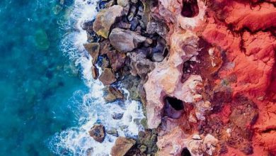 الشاطئ الأحمر والأحجار الملونة الجميلة وتصادم الموج الرقيق 390x220 - صورة الشاطئ الأحمر والأحجار الملونة الجميلة وتصادم الموج الرقيق
